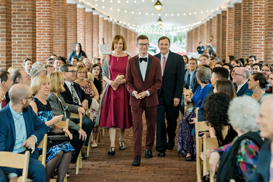 A groom walks down the isle with his parents in the Headhouse District of Philly.
